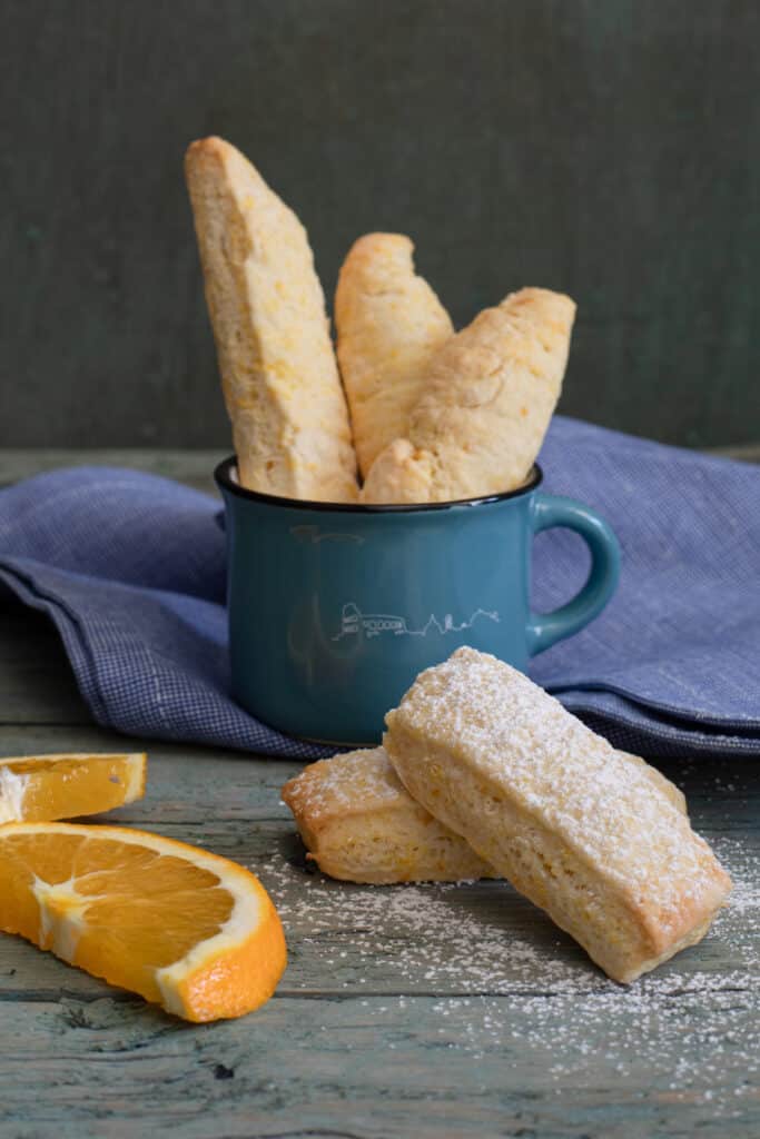 Cookies in a mug and two on a blue board.