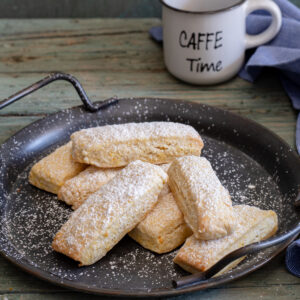 Dunking cookies on a black plate.