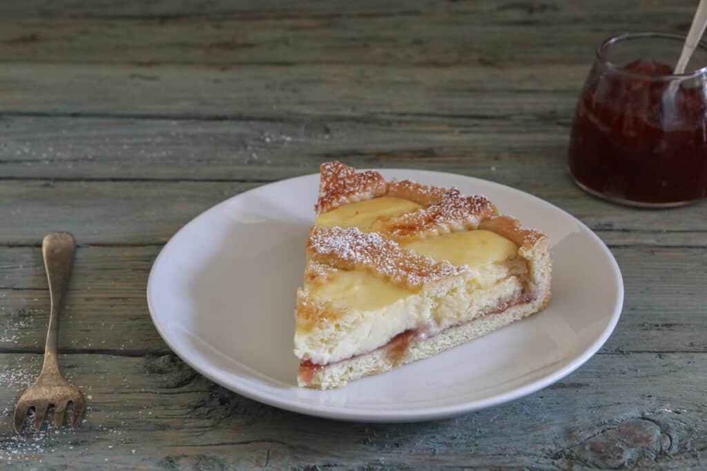 A slice of crostata on a white plate.