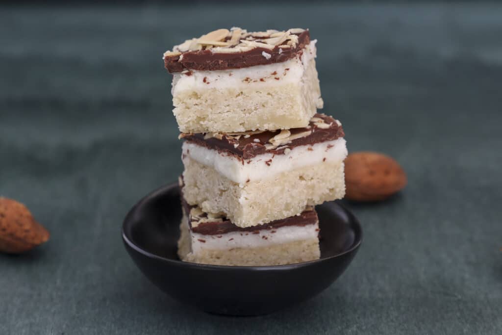 Three shortbread bars stacked on a black plate.