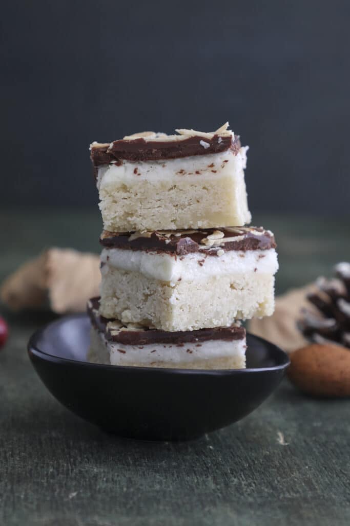 Three shortbread bars stacked on a black plate.