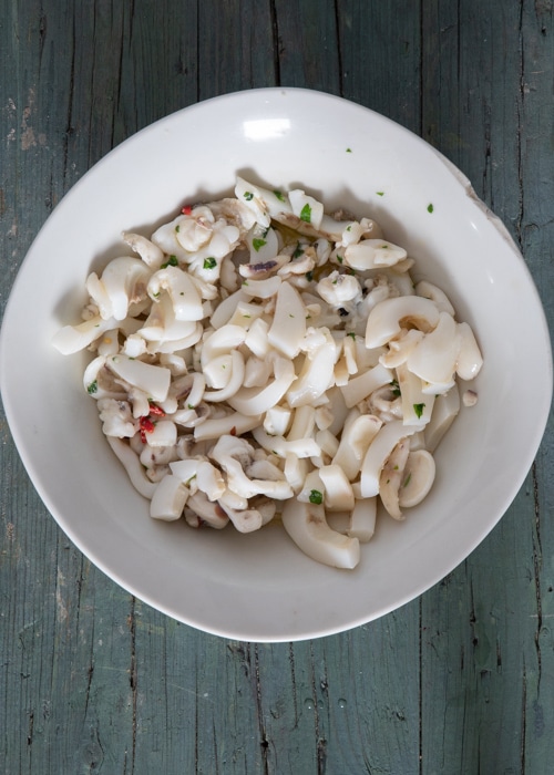 Cooked calamari in a white bowl.