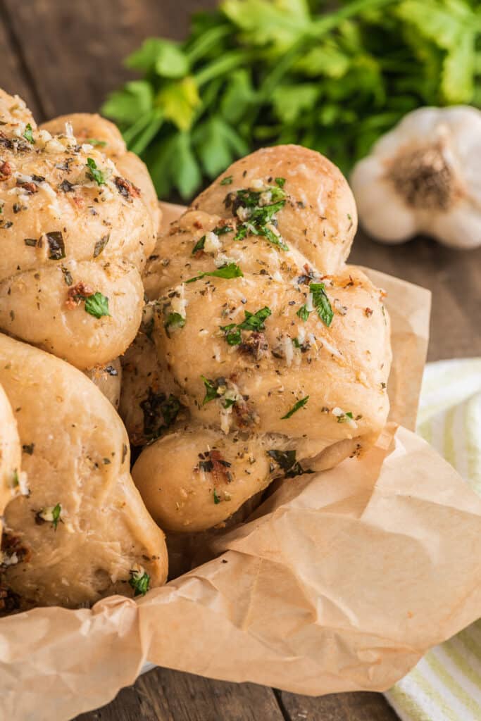 Garlic knots in a basket with paper.