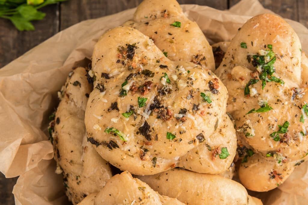 Garlic knots in a basket with paper.