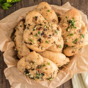 Garlic knots in a basket with paper.