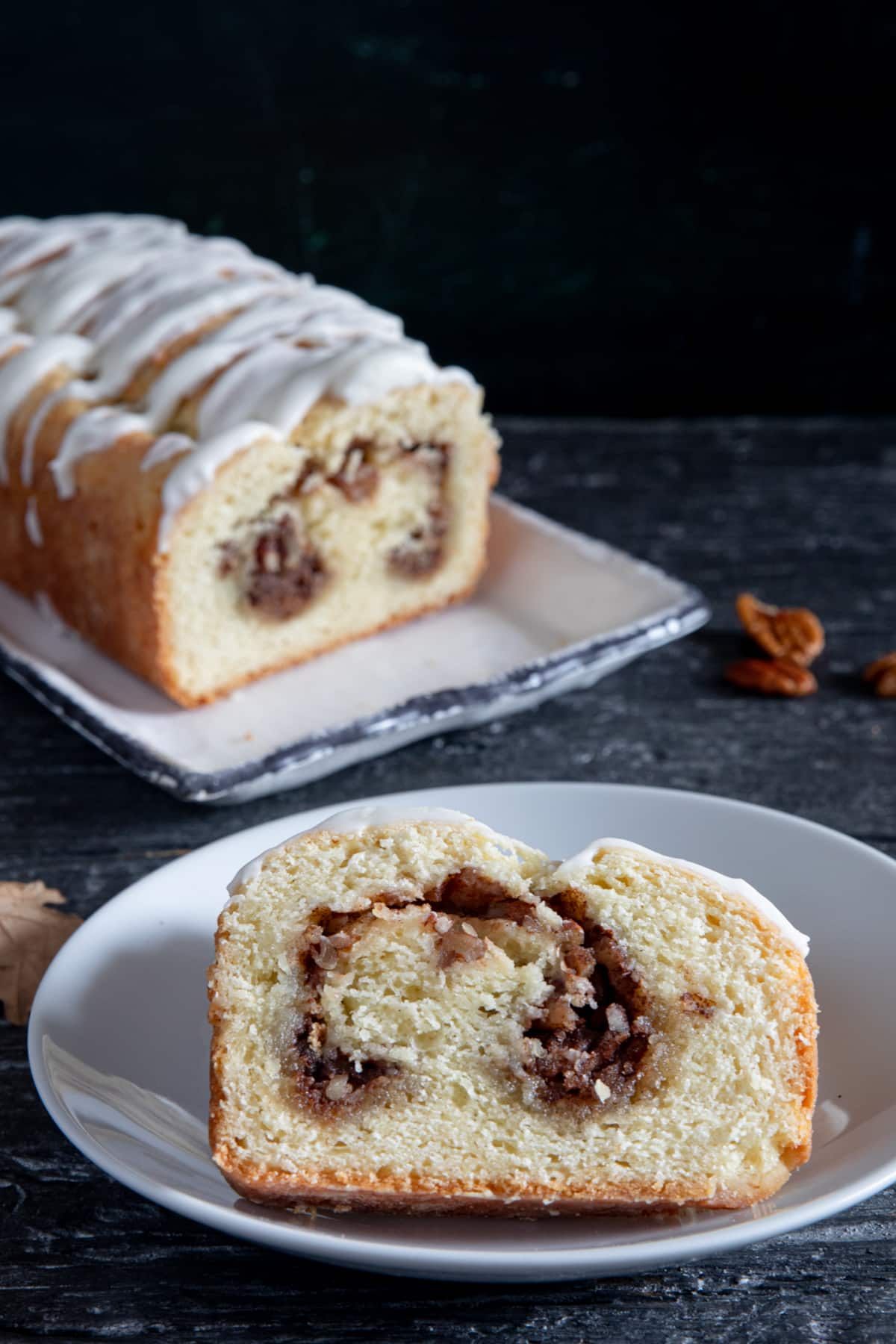 Cinnamon bread on a white plate with a slice cut.