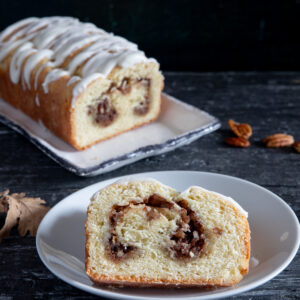 Cinnamon bread on a white plate with a slice cut.