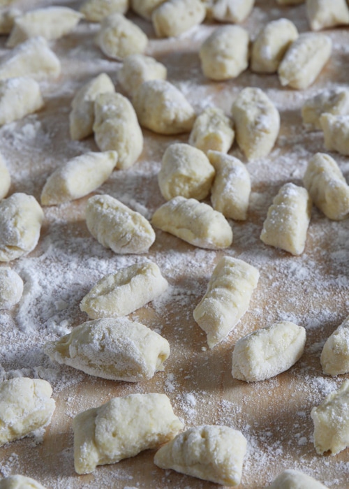 The gnocchi formed on a floured wooden board.