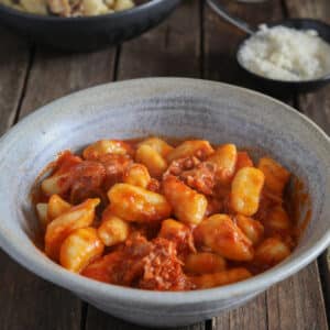 Gnocchi with sauce in a blue bowl.