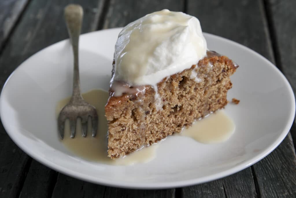 A slice of cake on a white plate.