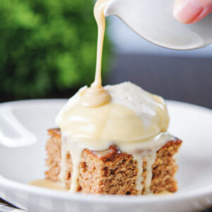 Pouring sauce on the pudding cake.