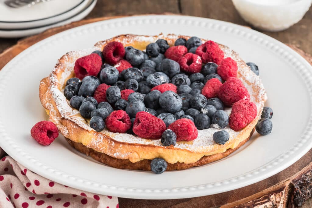 The berry puff on a white plate with berries on top.