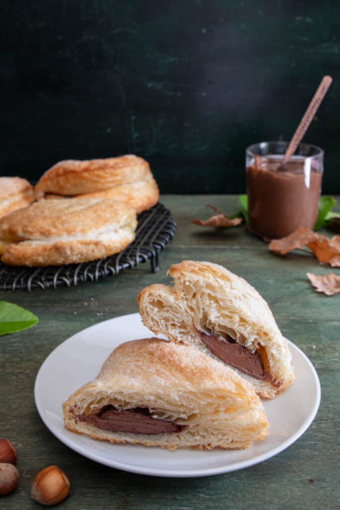 Ciavattoni on a wire rack with one cut in half on a white plate.