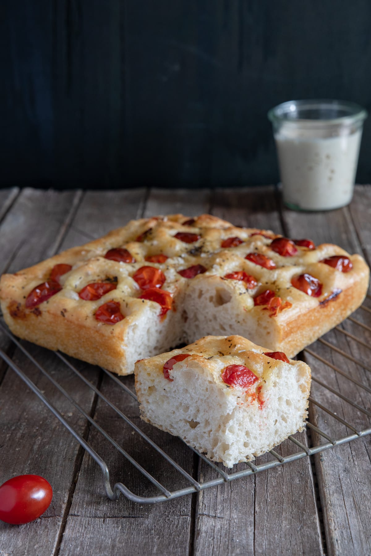 Focaccia on a wire rack with a slice cut.