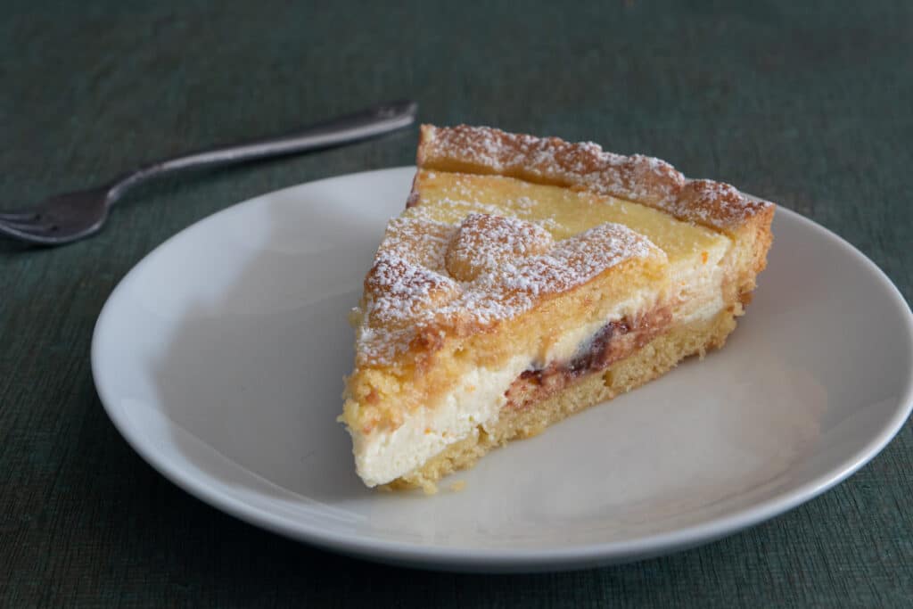 A slice of crostata on a white plate.