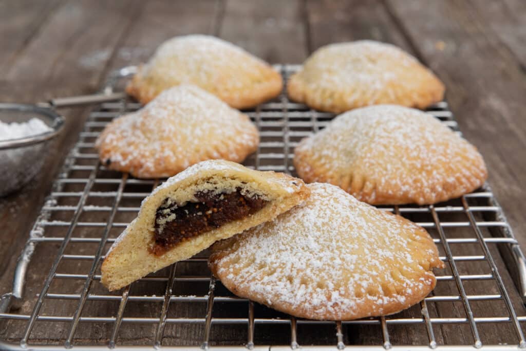 Cookies on a wire rack with one cut in half.