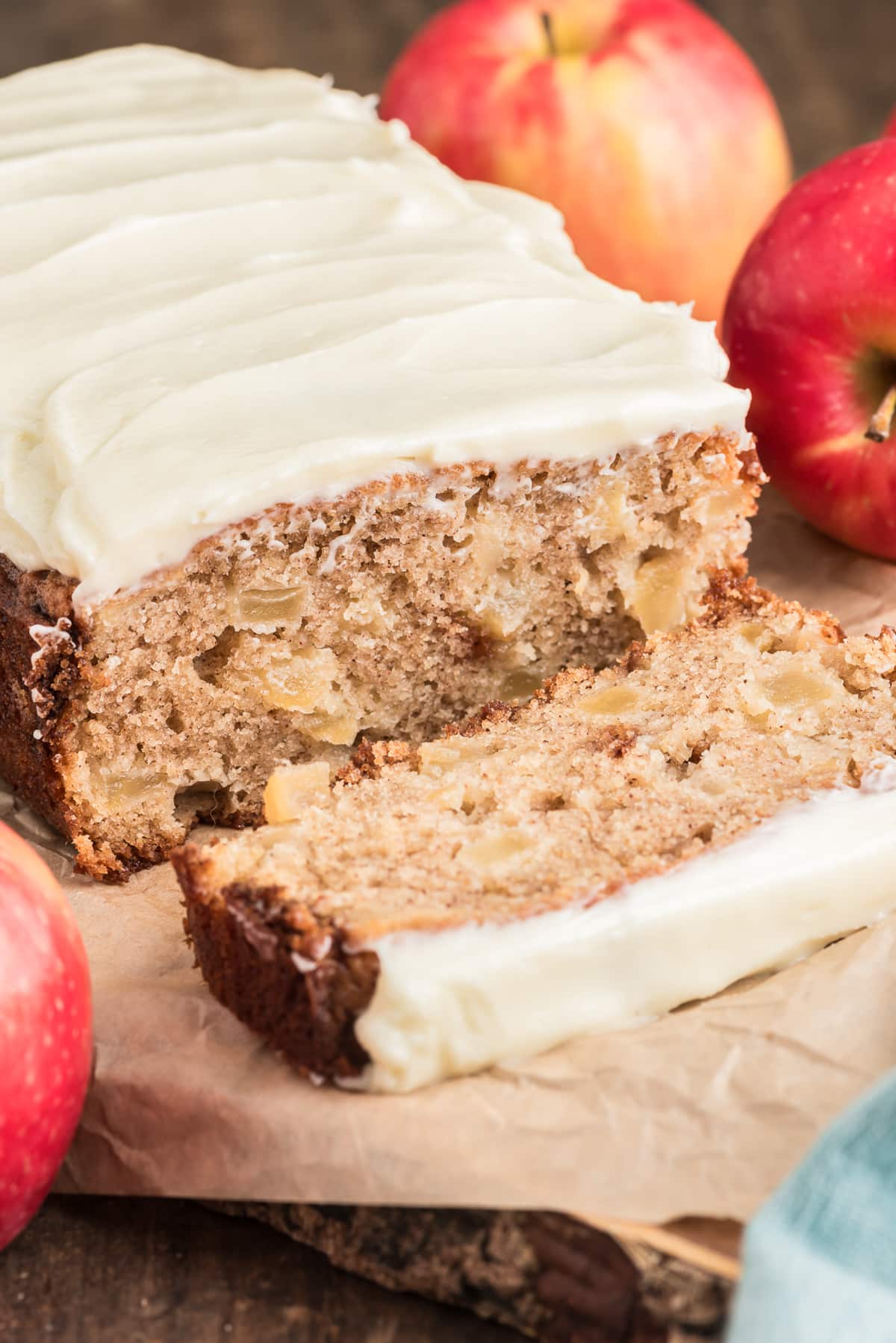Apple bread with a slice cut on a wooden board.