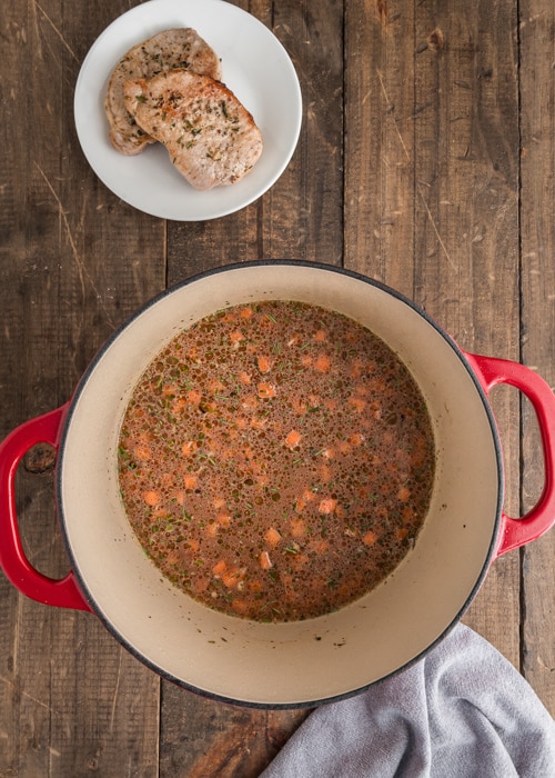 The rice mixture and broth in the dutch oven.