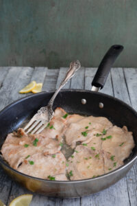 Veal piccata in a frying pan.