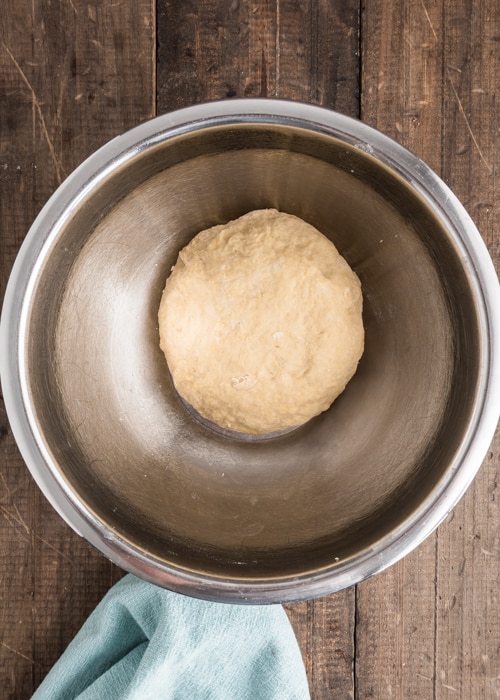 The dough in a silver bowl to rest.