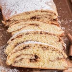 Cinnamon swirl loaf with four slices on a wooden board.