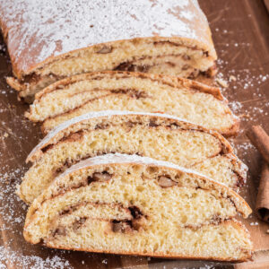 Cinnamon swirl loaf with four slices on a wooden board.