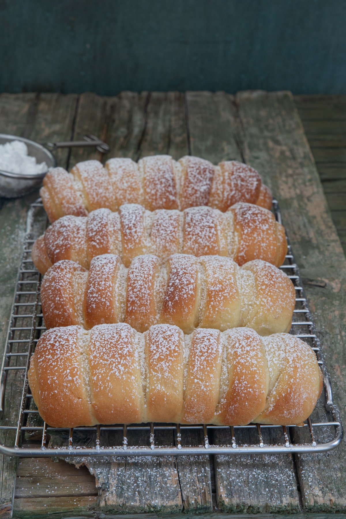 Four Easter buns on a wire rack.