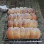 Four Easter buns on a wire rack.