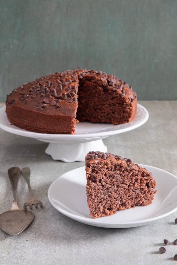 Chocolate cake with a slice on a white plate.