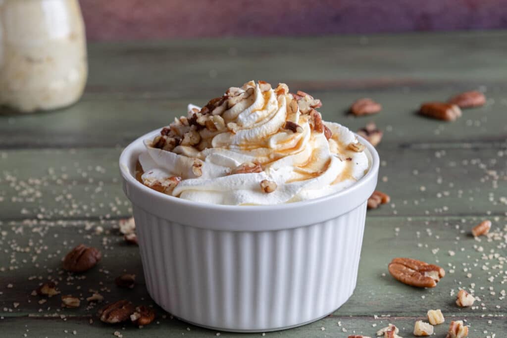 Maple mousse with syrup in a white bowl.