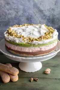 Spumoni ice cream cake on a white cake stand.