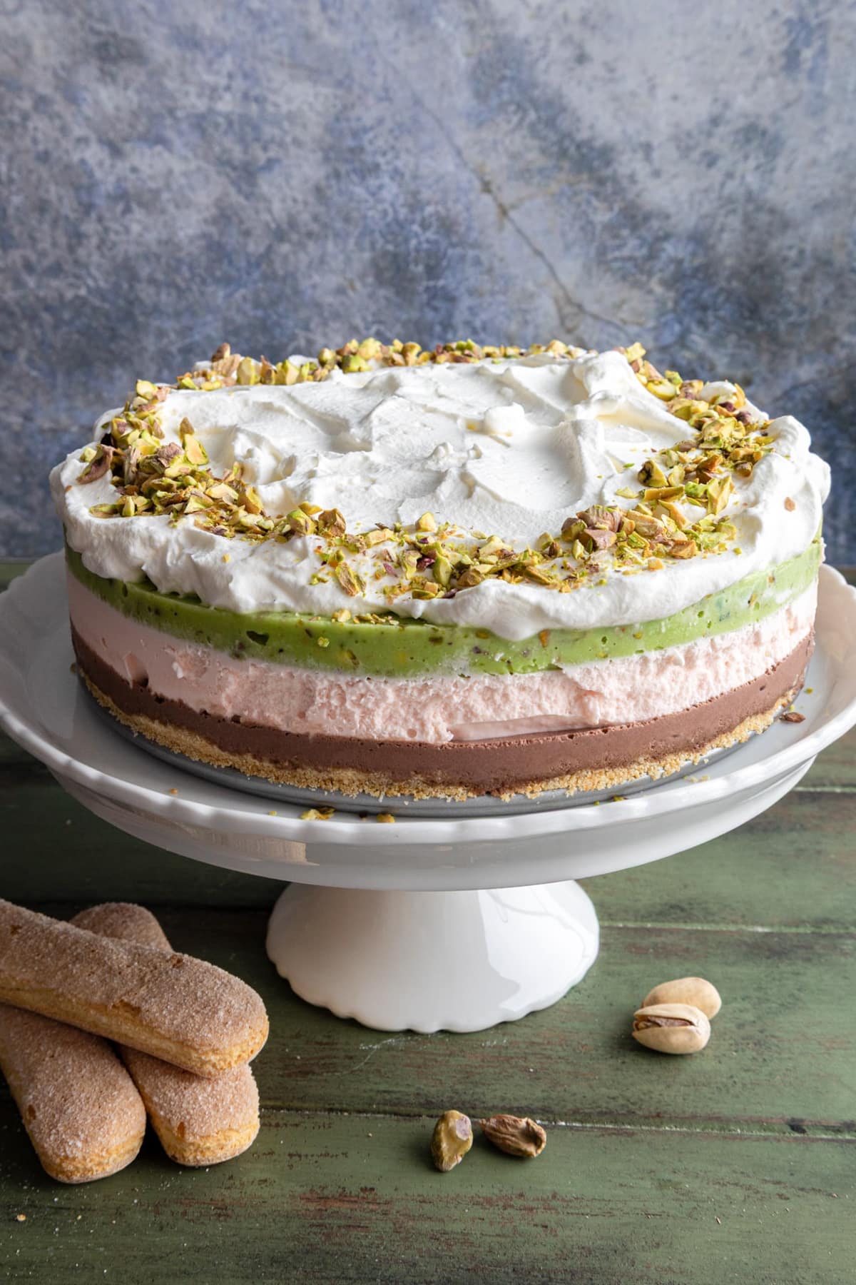 Spumoni ice cream cake on a white cake stand.