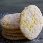 Four lemon cookies stacked with one leaning against them.