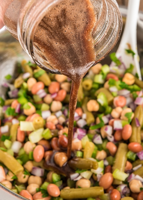 Pouring the dressing on the beans.