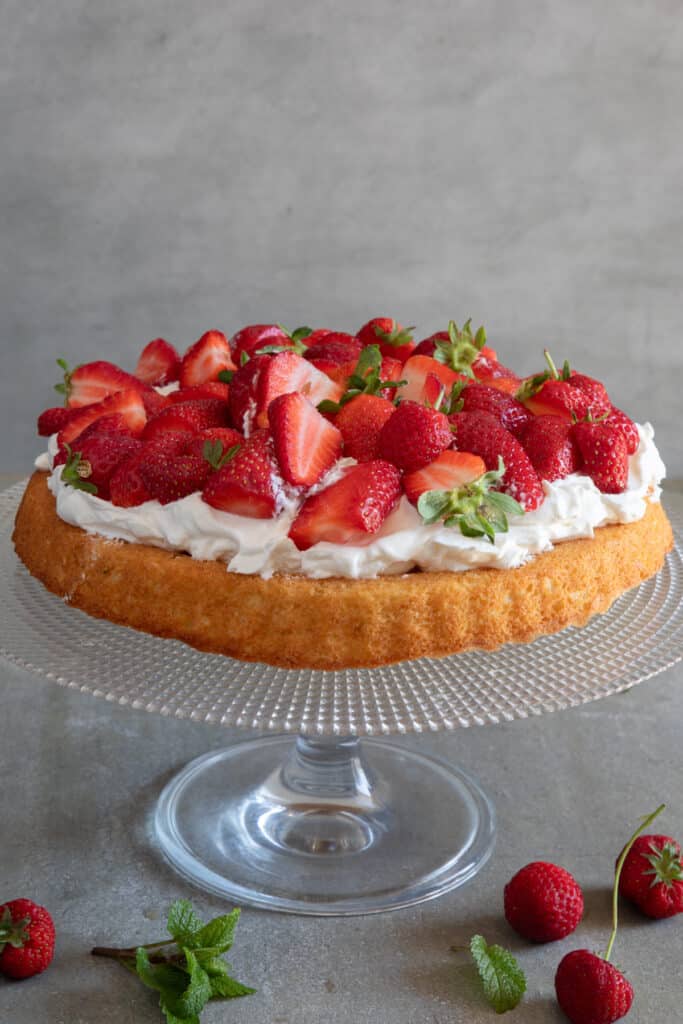 Strawberry crostata on a glass cake plate.
