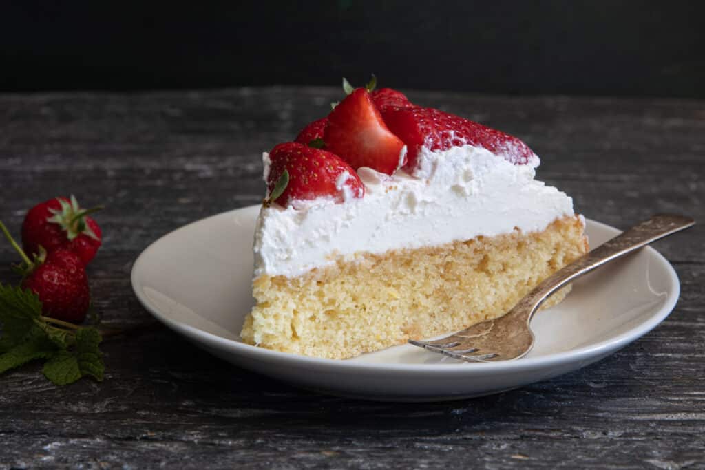A slice of cake on a white plate.
