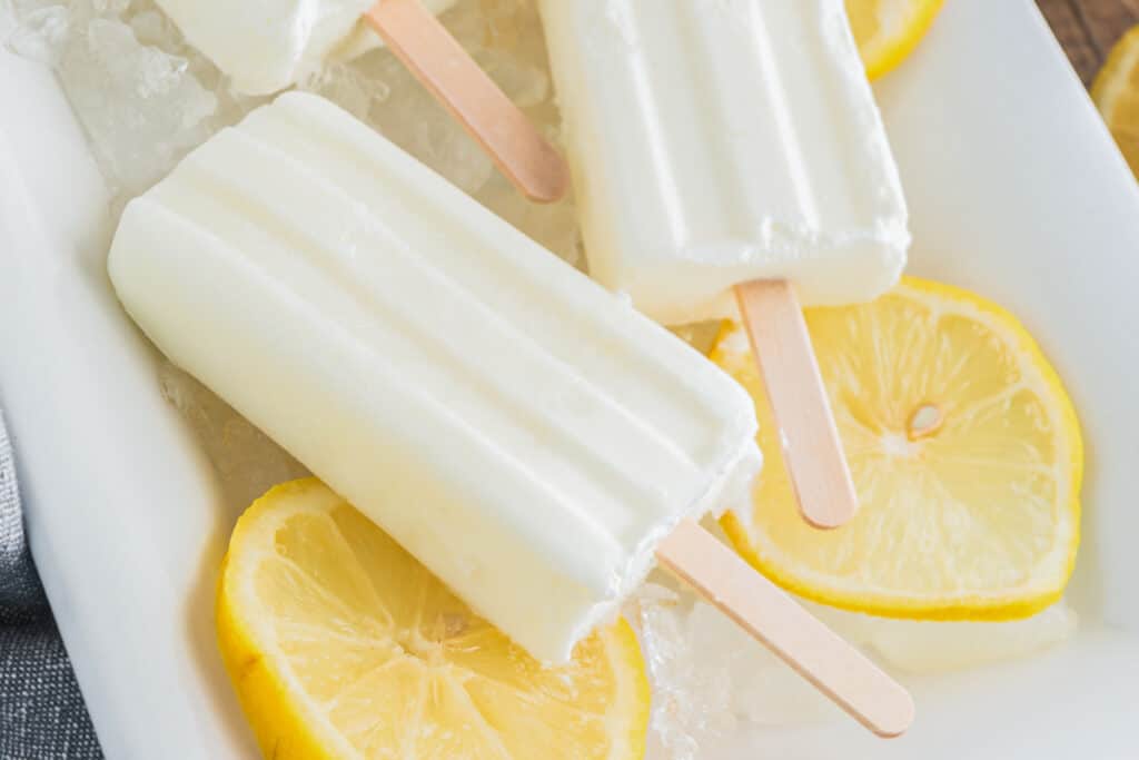 Lemon popsicles on a white plate.