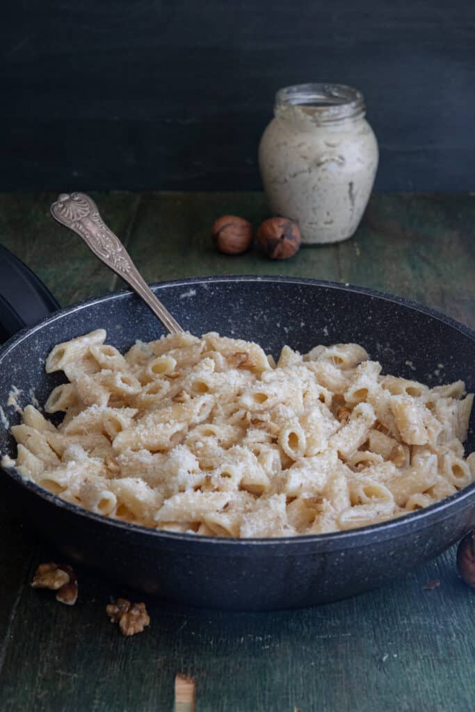 Pasta in a black pan made with walnut pesto.