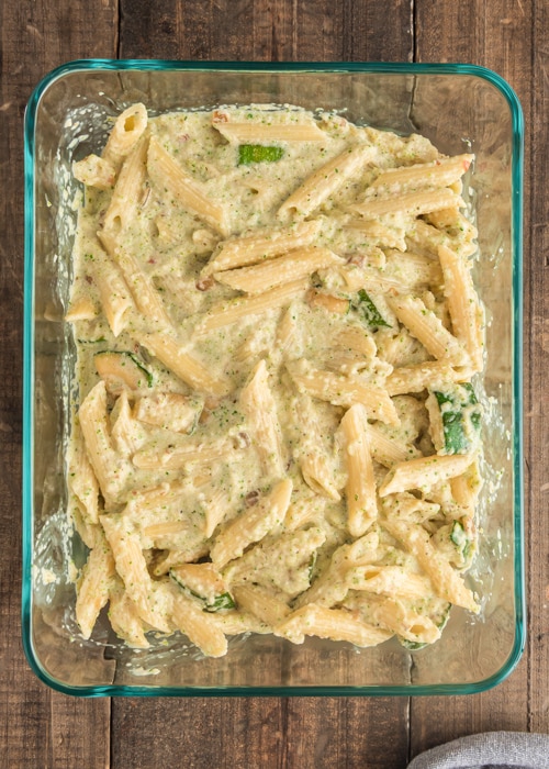 The pasta tossed with the sauce in the pan.