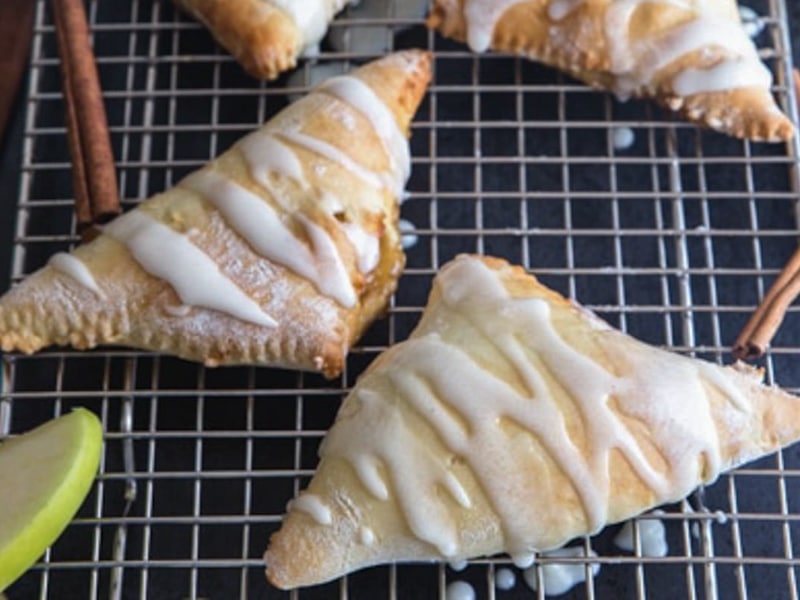 Apple pie turnovers on a wire rack.