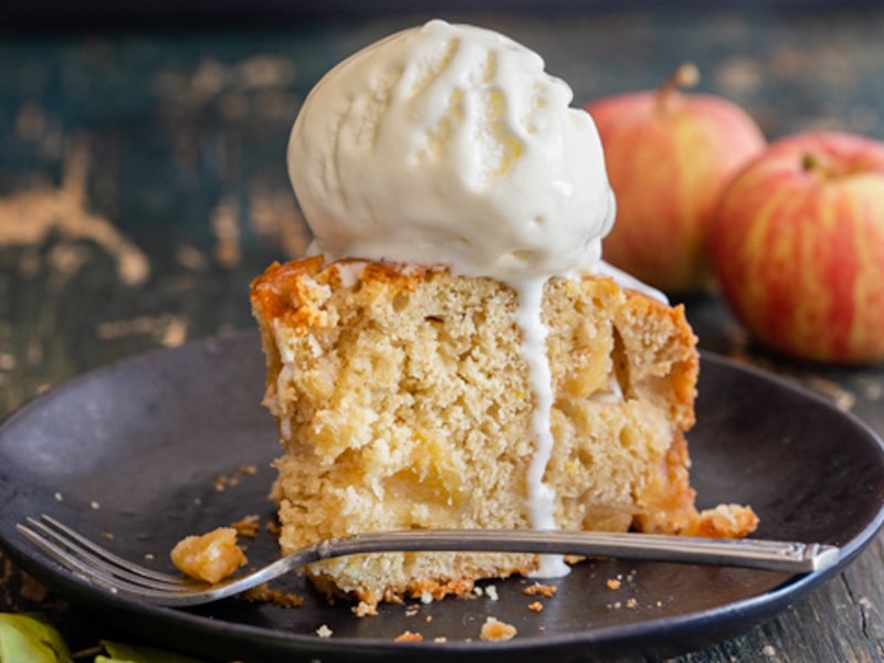 Caramel apple cake slice with a scoop of ice cream.