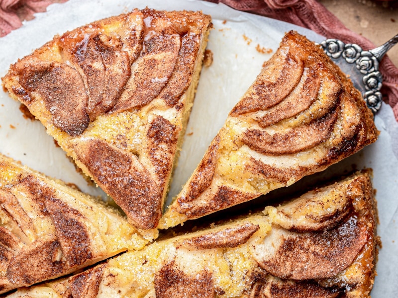 Apple cinnamon cake with three slices cut.
