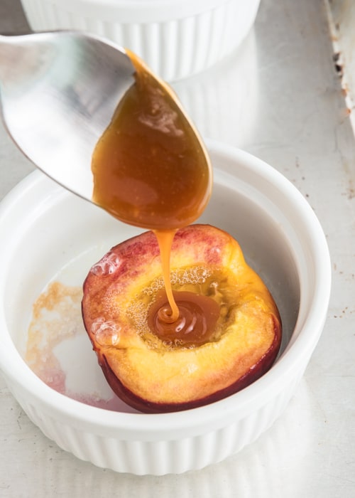 Pouring some sauce on the peaches.