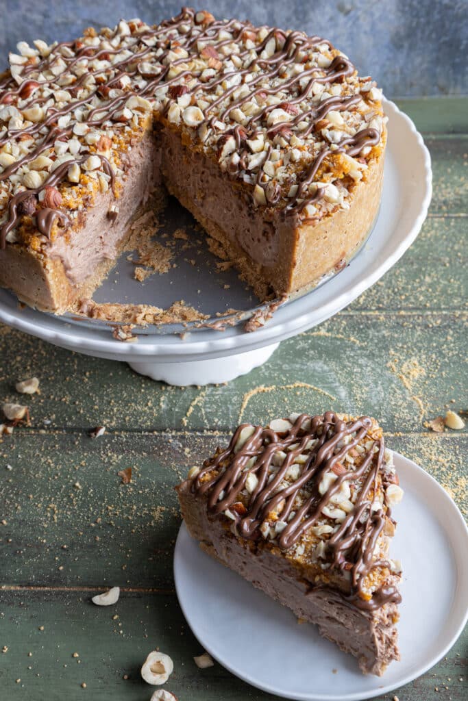 Hazelnut cake with a slice on a white plate.