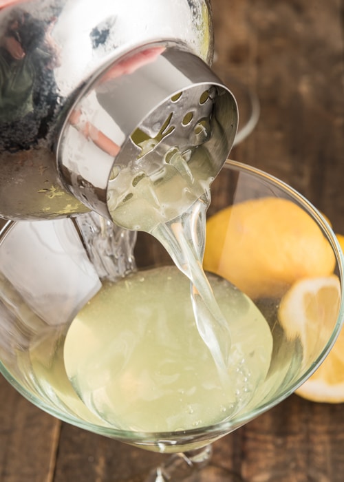 Pouring the drink into the martini glass.