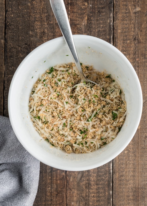 Mixing the bread crumb topping in a white bowl.