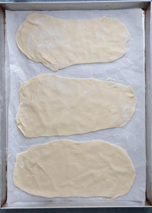 The rolled out dough on a parchment paper lined baking sheet.