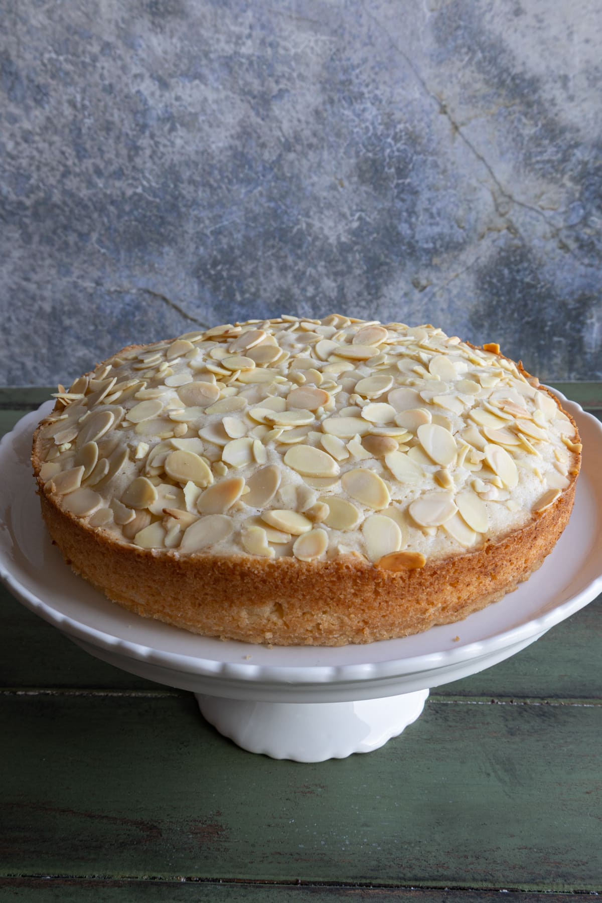 Almond cake on a white cake stand.