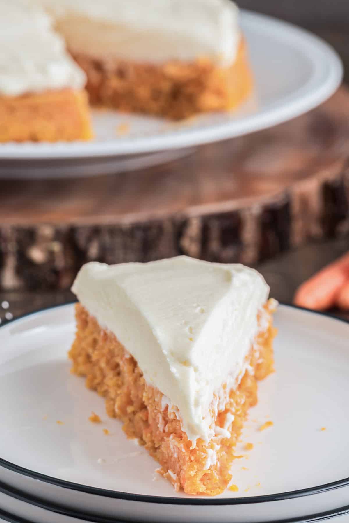 Carrot cake with a slice on a white plate.