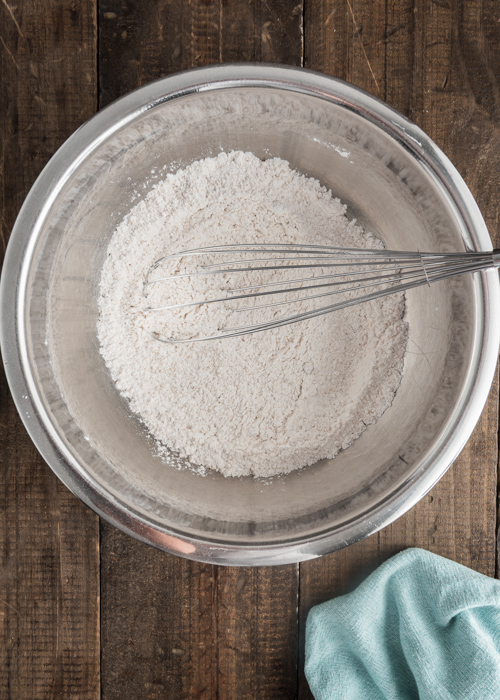 Whisking the dry ingredients in a silver bowl.